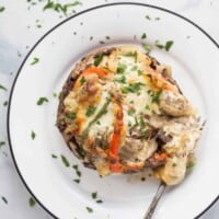 stuffed mushroom on a plate with peppers and melted cheese