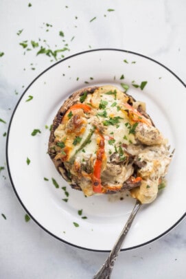 stuffed mushroom on a plate with peppers and melted cheese