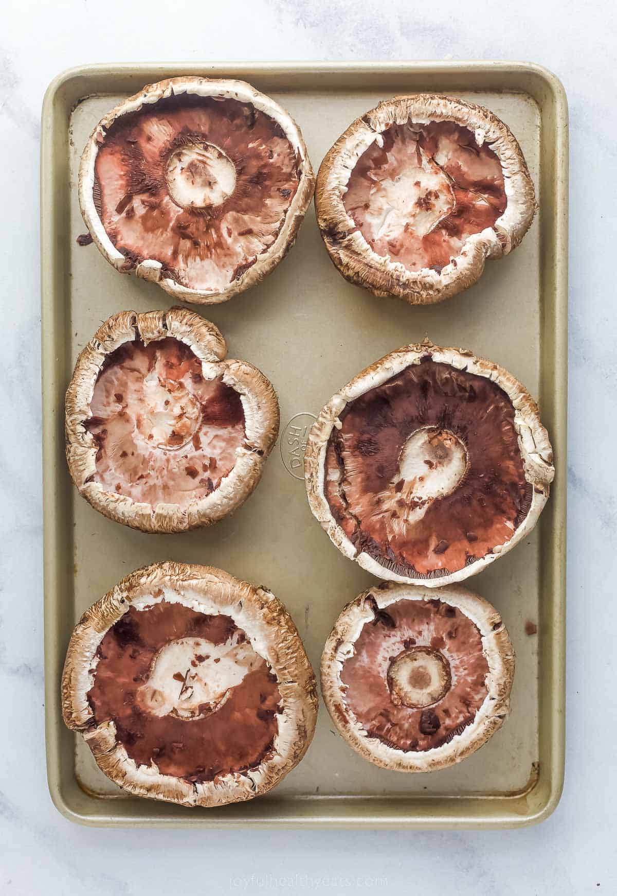 These Easy 30-Minute Philly Cheese Steak Stuffed Mushrooms are packed with tender steak, sautéed vegetables, and gooey cheese. large mushrooms on a sheet tray