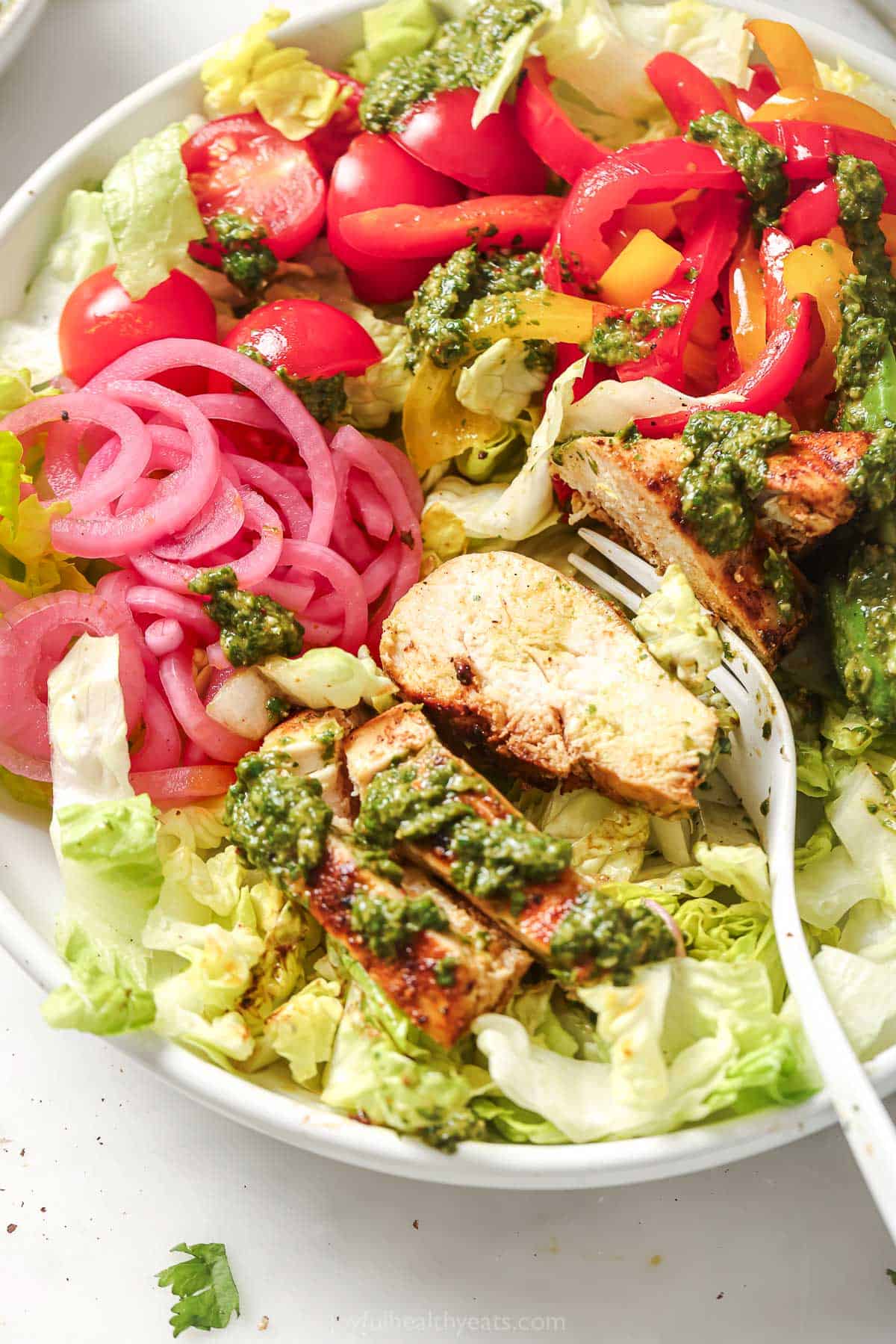 Digging into the chicken fajita salad with a fork.