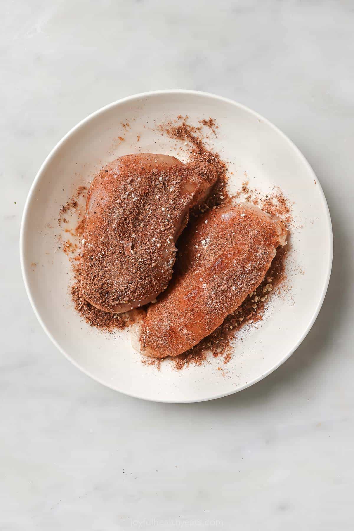 Seasoning the chicken with the spice mix. 