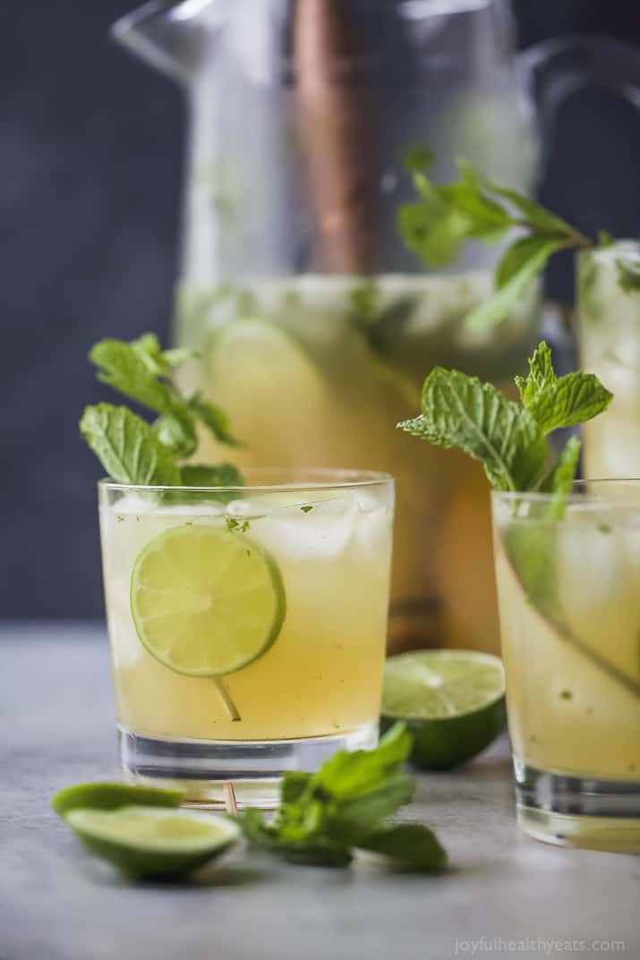 Two glasses of Mojitos with mint and lime garnish