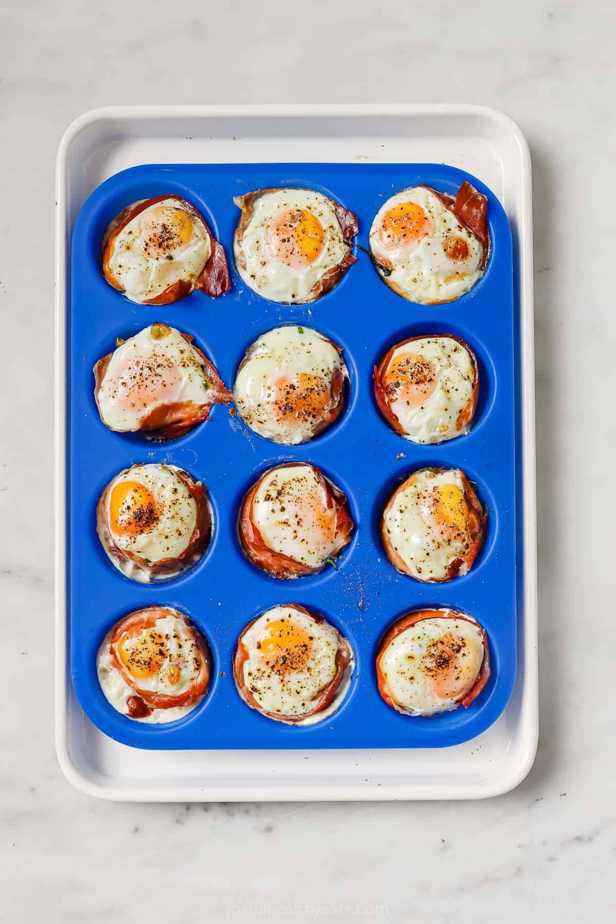 Place cooked egg cups into muffin trays. 