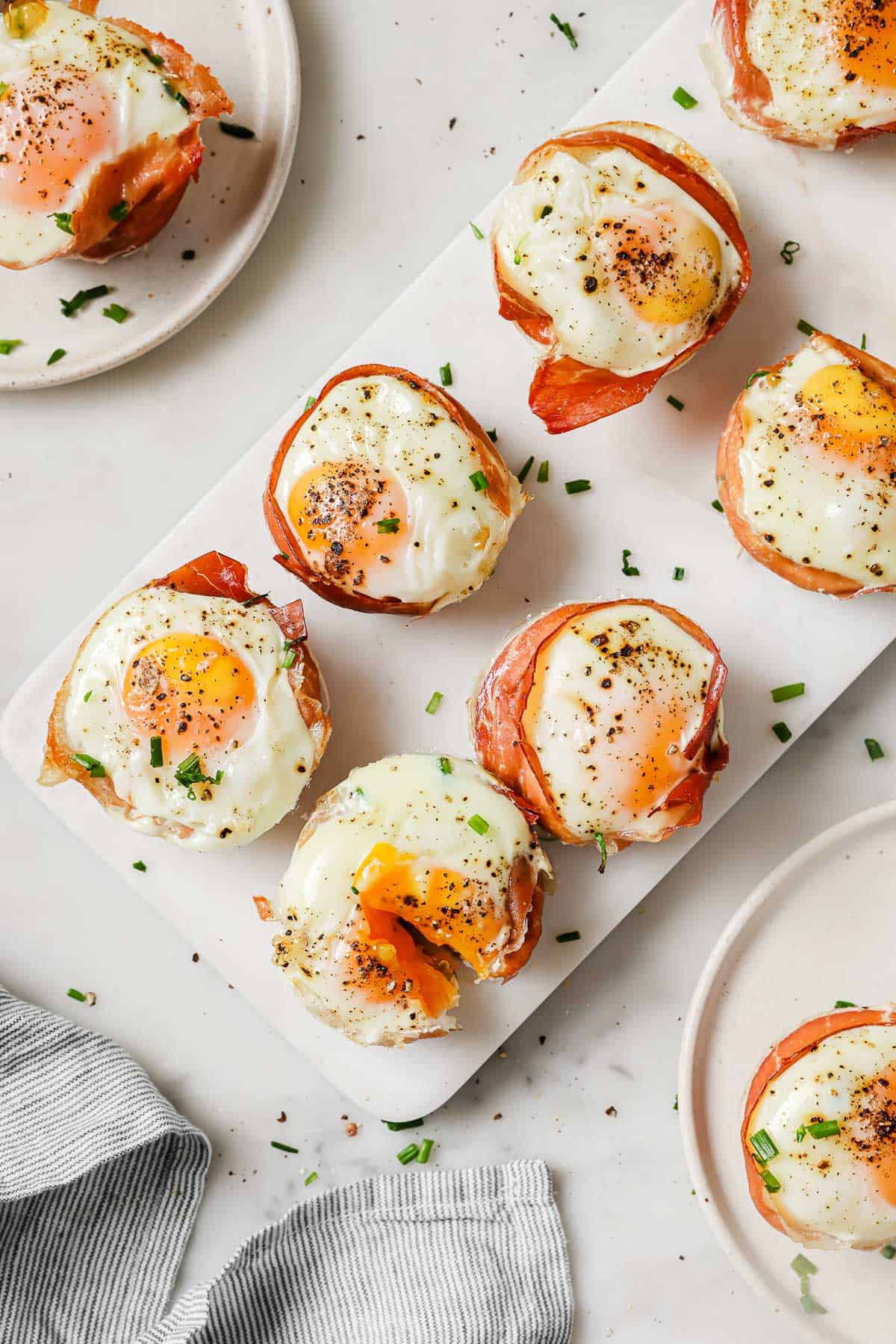 Six prosciutto baked egg cups on a serving tray. 