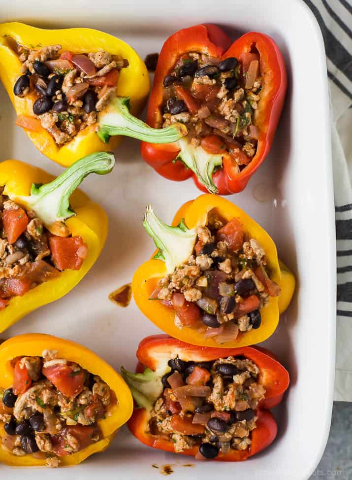 Cheesy Turkey Enchilada Stuffed Peppers filled with tex-mex flavor and covered in melty cheese. These gluten free Stuffed Peppers make an absolutely delicious healthy weeknight dinner for the family.