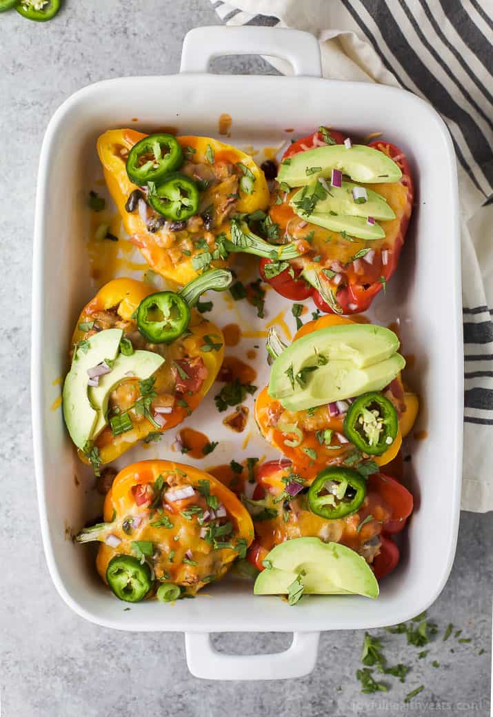 Cheesy Turkey Enchilada Stuffed Peppers filled with tex-mex flavor and covered in melty cheese. These gluten free Stuffed Peppers make an absolutely delicious healthy weeknight dinner for the family.