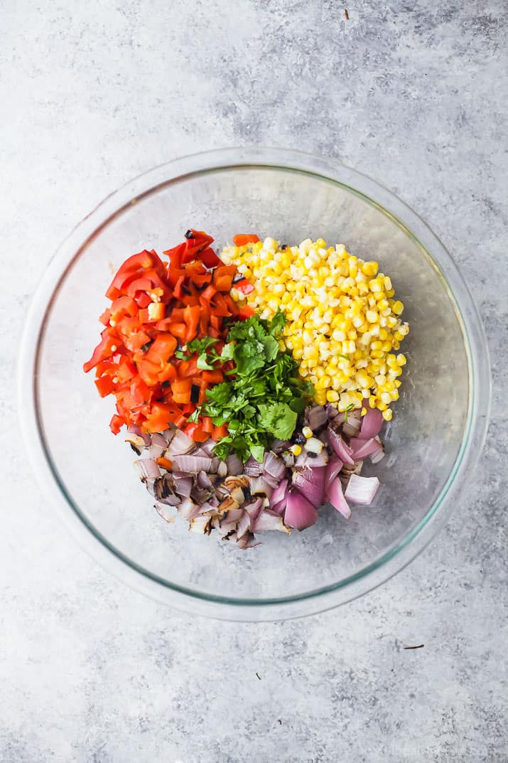 Chopped vegetables for Charred Corn Roasted Red Pepper Farro Salad in a mixing bowl