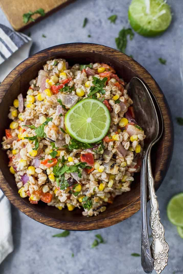 Top view of a bowl of Farro Salad filled with Char Grilled Corn, Roasted Red Pepper and creamy goat cheese