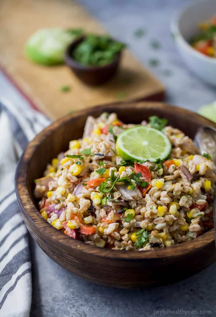 A bowl of Farro Salad filled with Char Grilled Corn, Roasted Red Pepper and creamy goat cheese