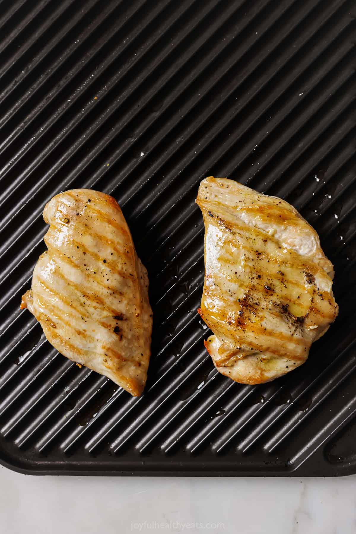 Two pieces of grilled chicken. 