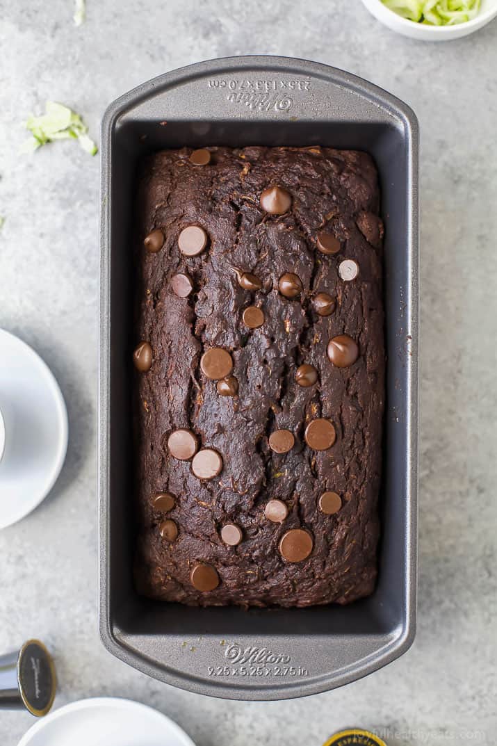This tender chocolate zucchini bread recipe with maple syrup, applesauce, and dark chocolate chips will be your new favorite breakfast. Whole chocolate zucchini loaf in the loaf pan.