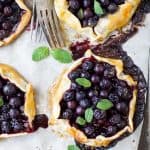 Fresh Mini Blueberry Galettes - a quick dessert perfect for a light sweet treat! Crispy flaky pie dough stuffed with bursting blueberries and topped with vanilla creme fraiche. These galettes are sure to please a crowd!