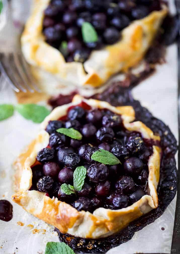 Close-up Two Fresh Mini Blueberry Galettes on parchment paper