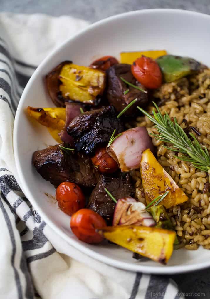 Beef kabobs with rice and fresh rosemary in a bowl