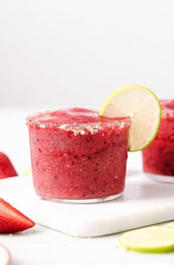 Icy berry margarita with a lime-sugar rim and a lime wedge.
