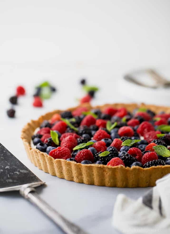 Berry Tart filled with a creamy greek yogurt cheesecake filling and an Almond Crust