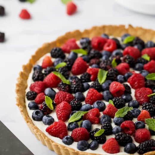 Gluten Free Berry Tart filled with a creamy greek yogurt cheesecake filling and an Almond Crust. This beautiful Berry Tart is a light dessert that's perfect for the summer!