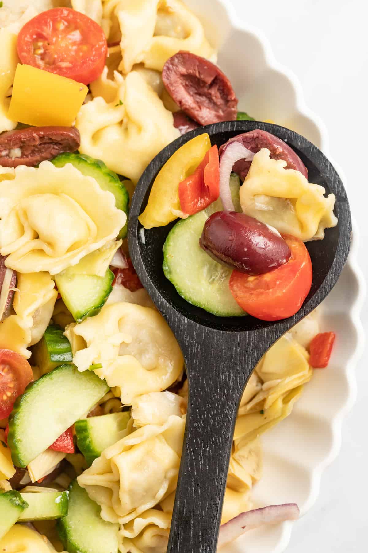 Close-up of s،ful of Greek pasta salad. 