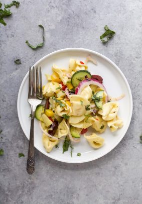 Easy 30 Minute Greek Tortellini Salad tossed with mediterranean veggies and a homemade greek vinaigrette for a lighter healthier taste. This Tortellini Pasta Salad is guaranteed to be the star at your summer BBQ's.