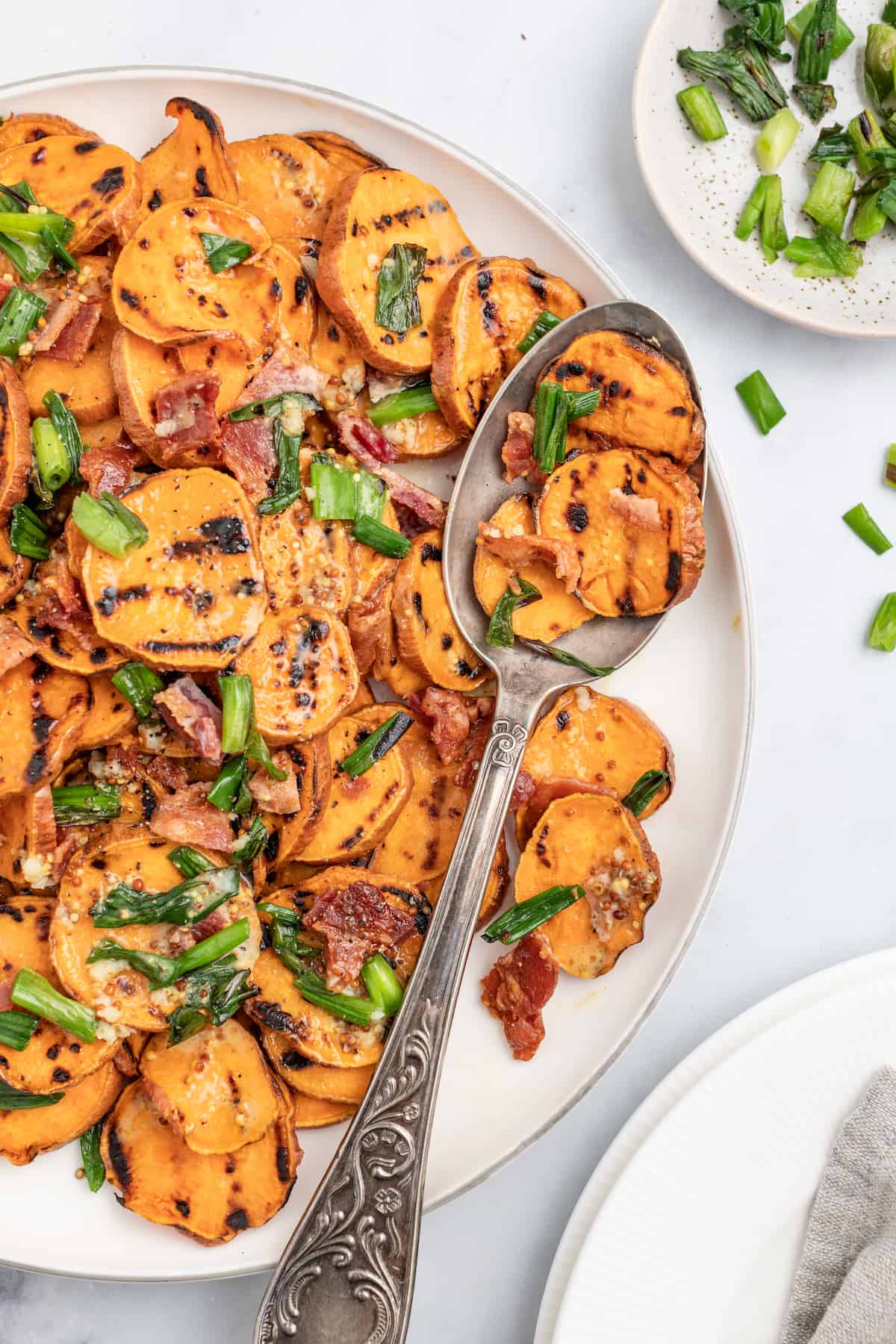 This 30-minute grilled sweet potato salad with bacon and honey mustard dressing is an easy side you'll be making on repeat this summer. Healthy sweet potato salad with a spoon.