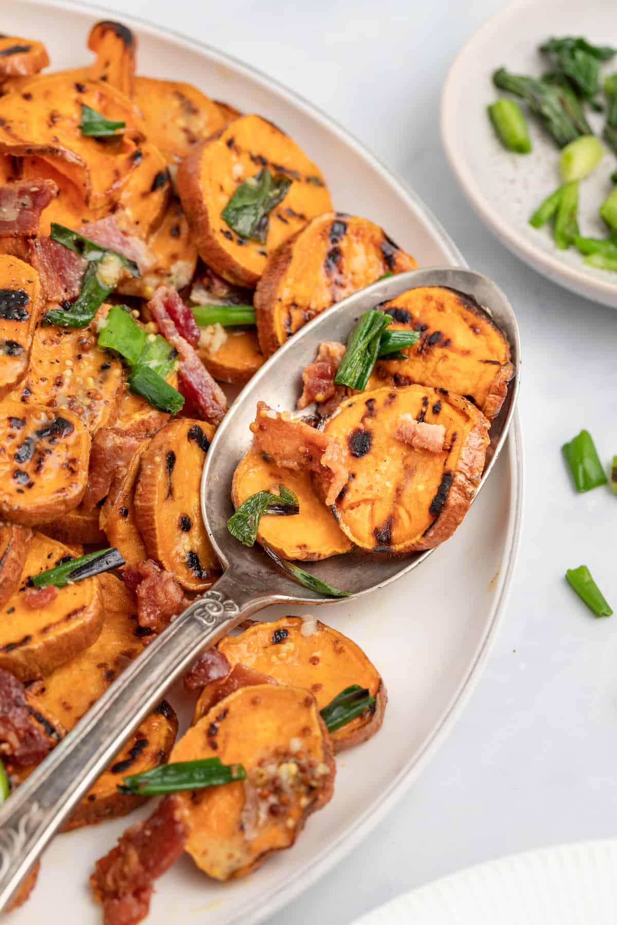 This 30-minute grilled sweet potato salad with bacon and honey mustard dressing is an easy side you'll be making on repeat this summer. Spoonful of sweet potato salad.