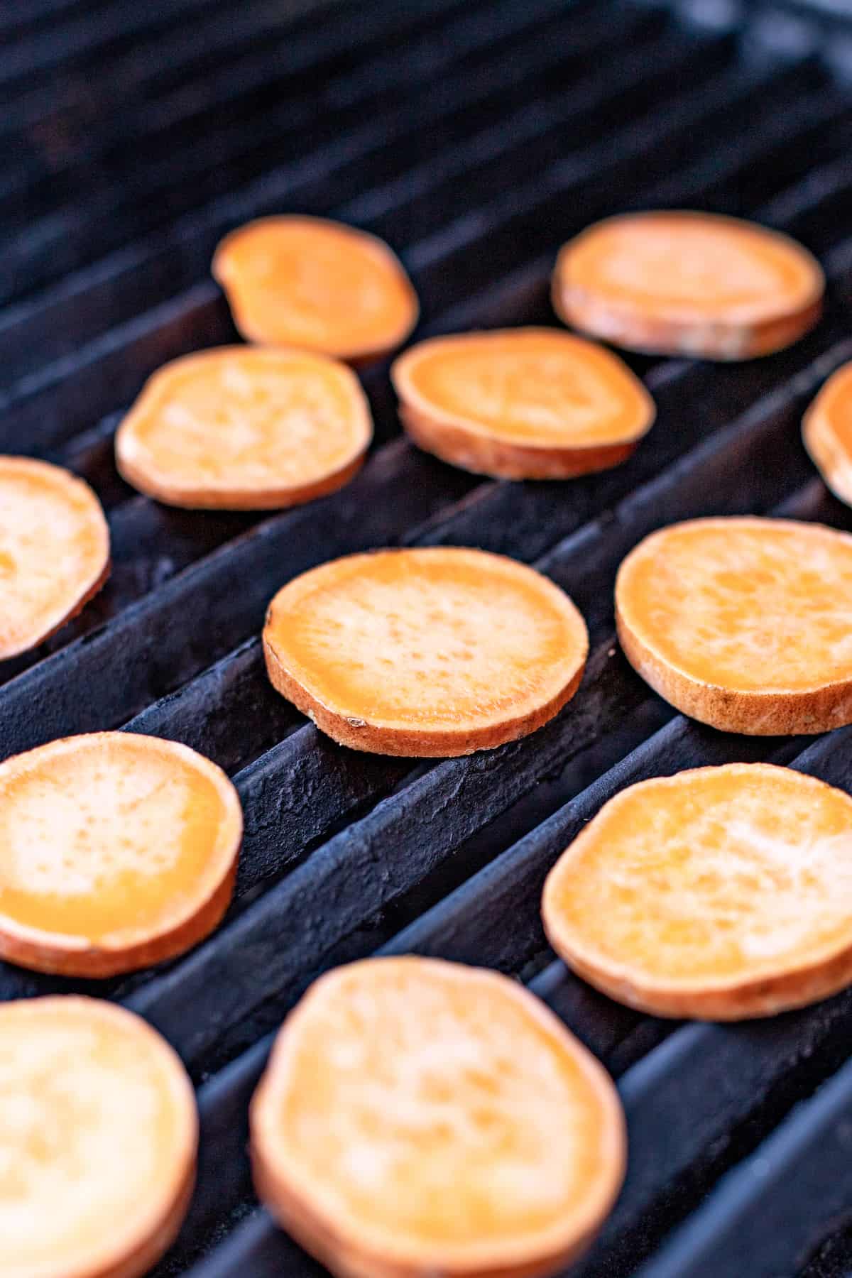 Placing the sweet potatoes on the grill. 