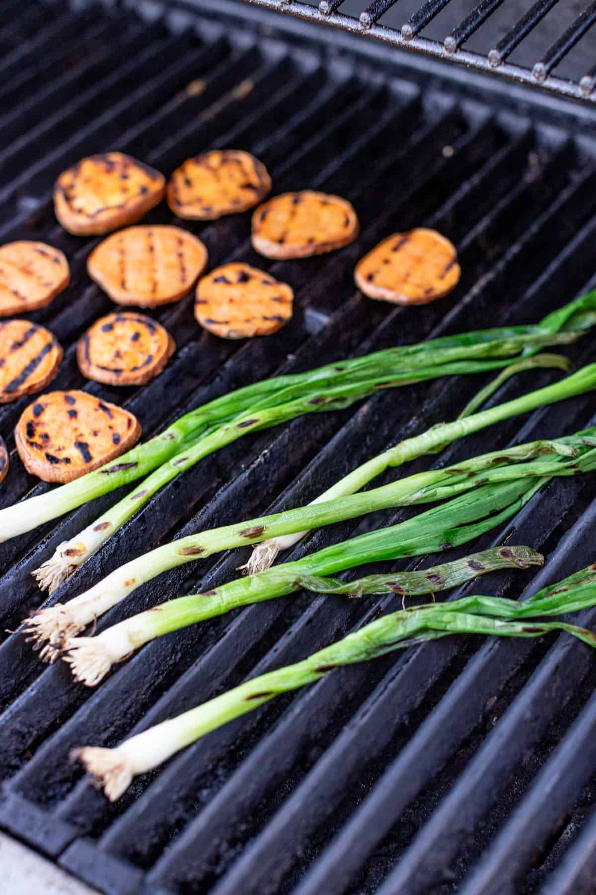 Charred green onions and sweet potatoes on the grill. 