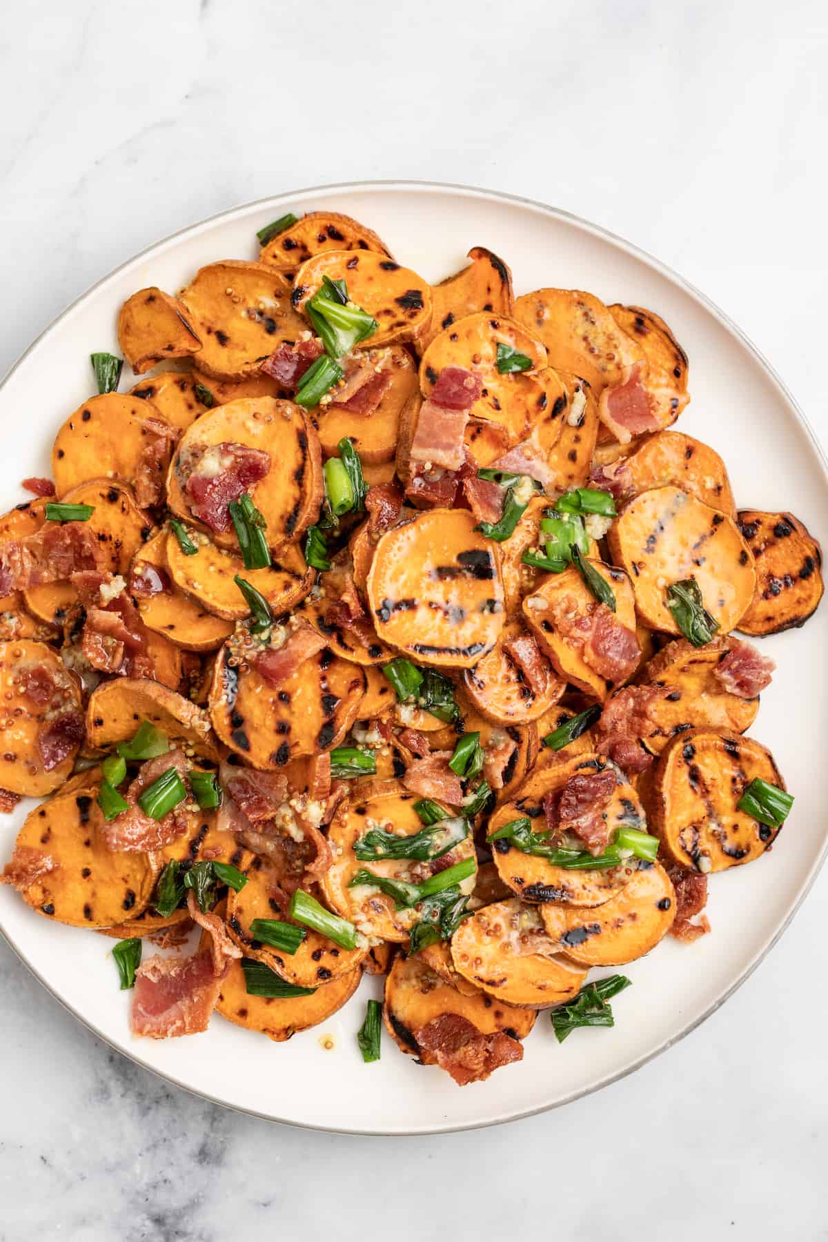 This 30-minute grilled sweet potato salad with bacon and honey mustard dressing is an easy side you'll be making on repeat this summer. Plate with healthy sweet potato salad.