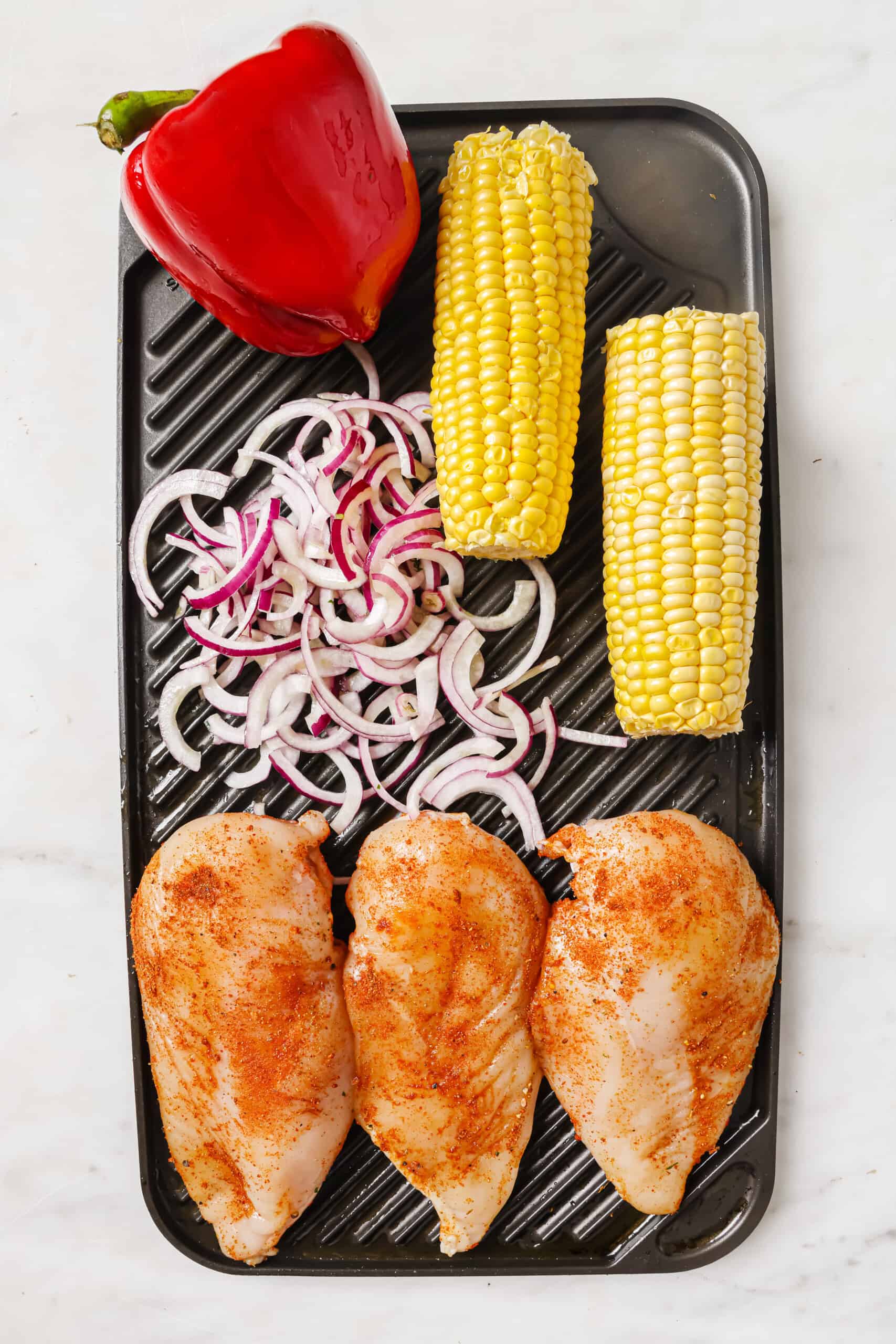 Placing the veggies and chicken on the grill.