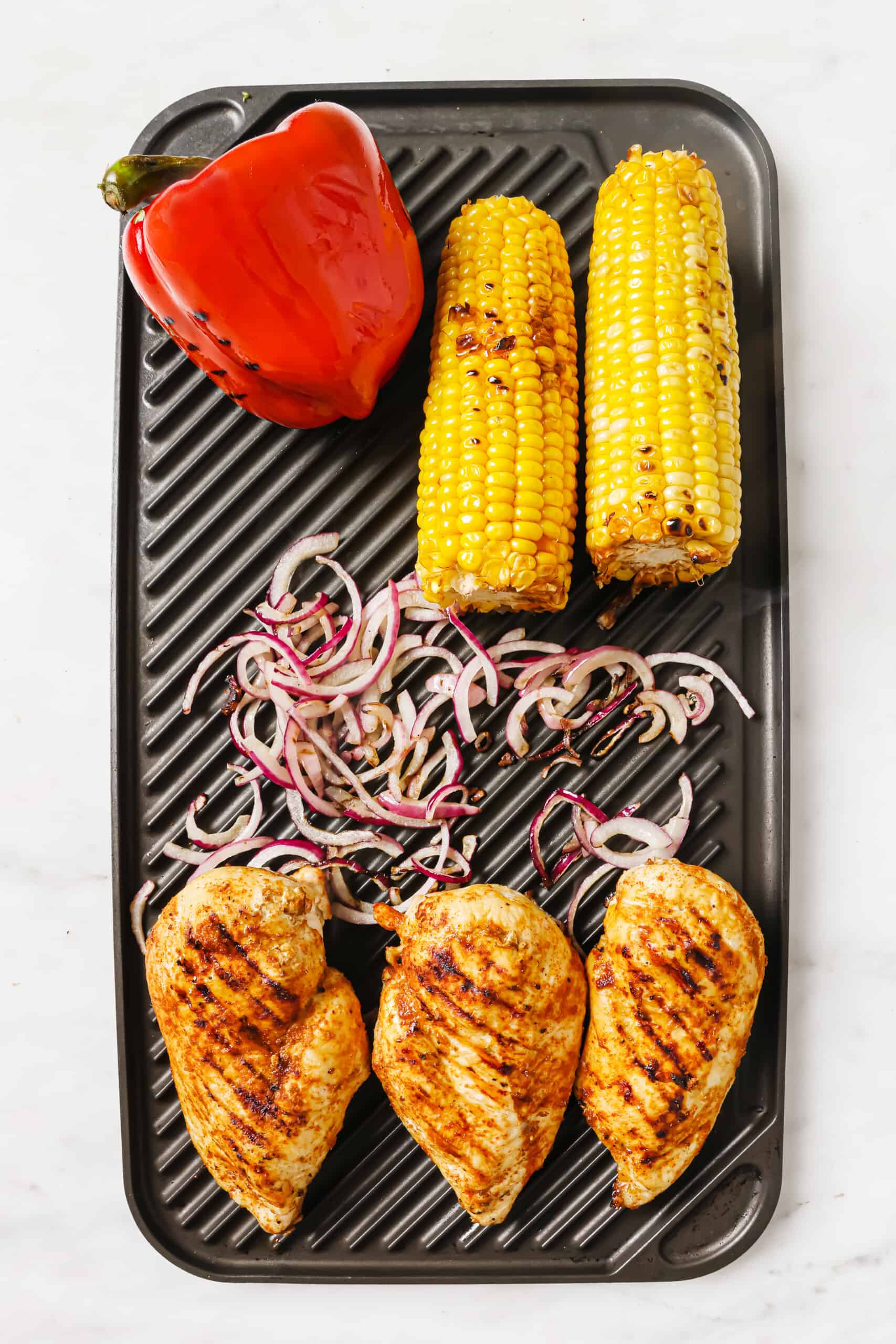 Grilled chicken and veggies on the grill.