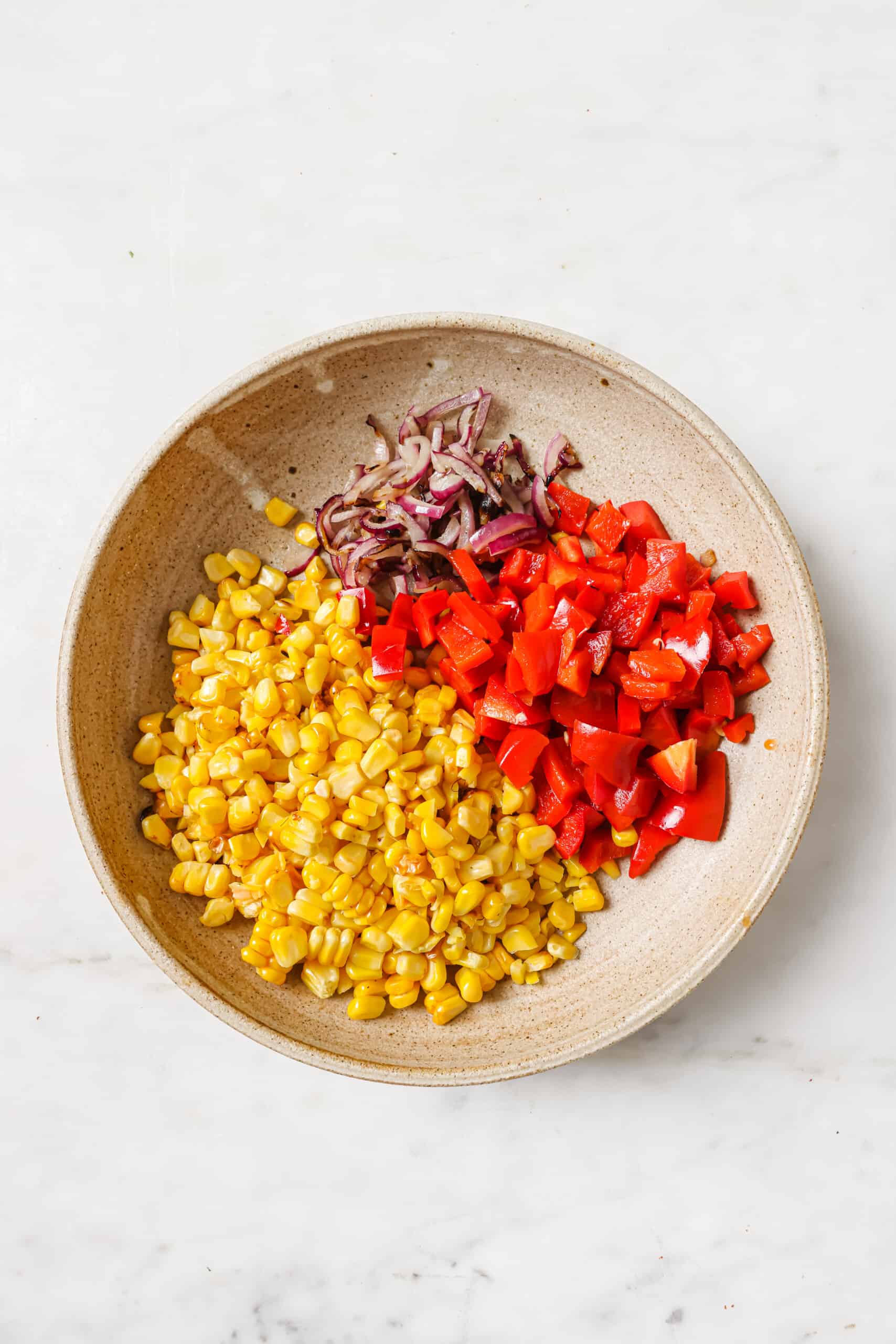 Chopped grilled veggies in a bowl.
