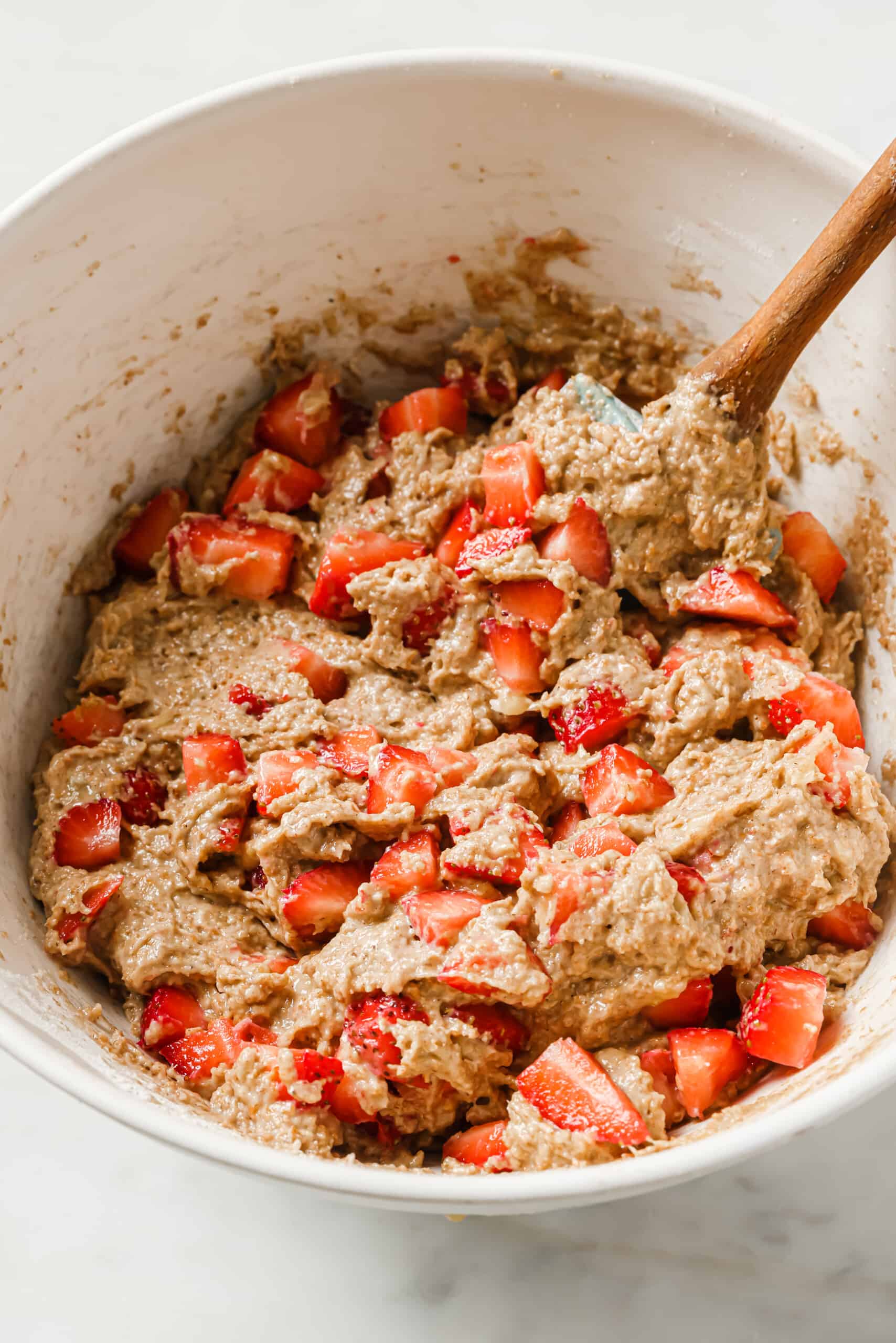 Folding the strawberries into the batter.