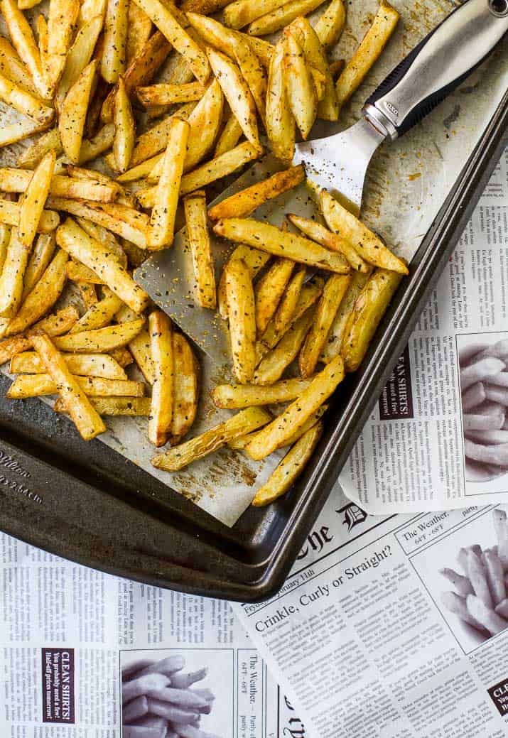 Crispy Oven Baked Fries on a sheet pan with a spatula