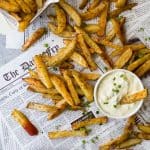 These Crispy Oven Baked Fries served with a Roasted Garlic Aioli make the perfect side dish for summer. These homemade french fries are baked instead of fried for a guilt free bite that can be served with anything!