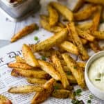 These Crispy Oven Baked Fries served with a Roasted Garlic Aioli make the perfect side dish for summer. These homemade french fries are baked instead of fried for a guilt free bite that can be served with anything!