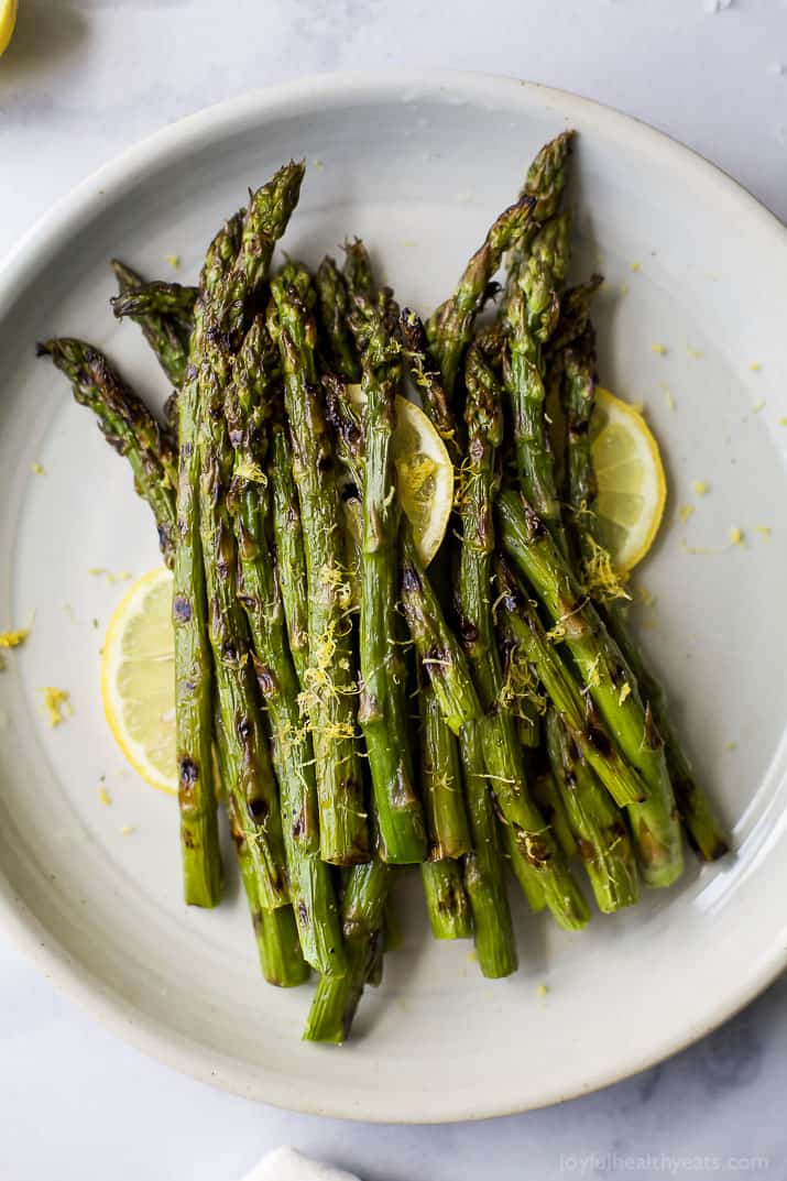 Grilled Asparagus topped with fresh Lemon zest on a plate