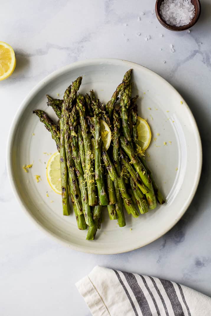 Grilled Asparagus topped with fresh Lemon zest on a plate