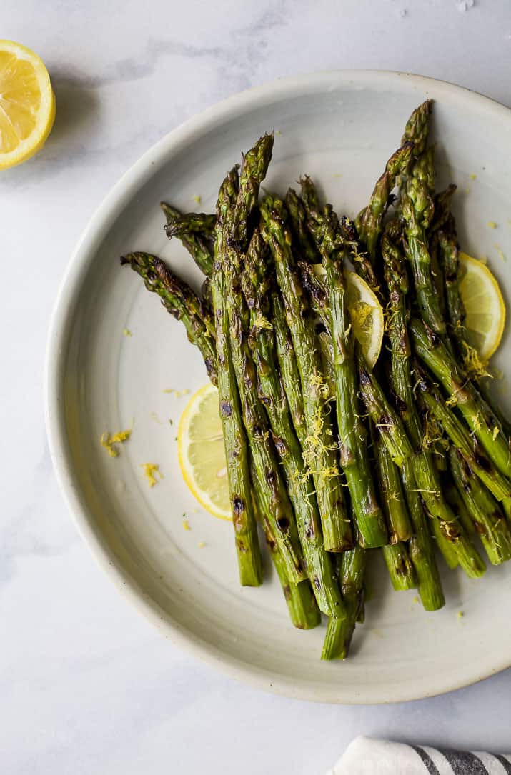 Grilled Asparagus topped with fresh Lemon zest on a plate