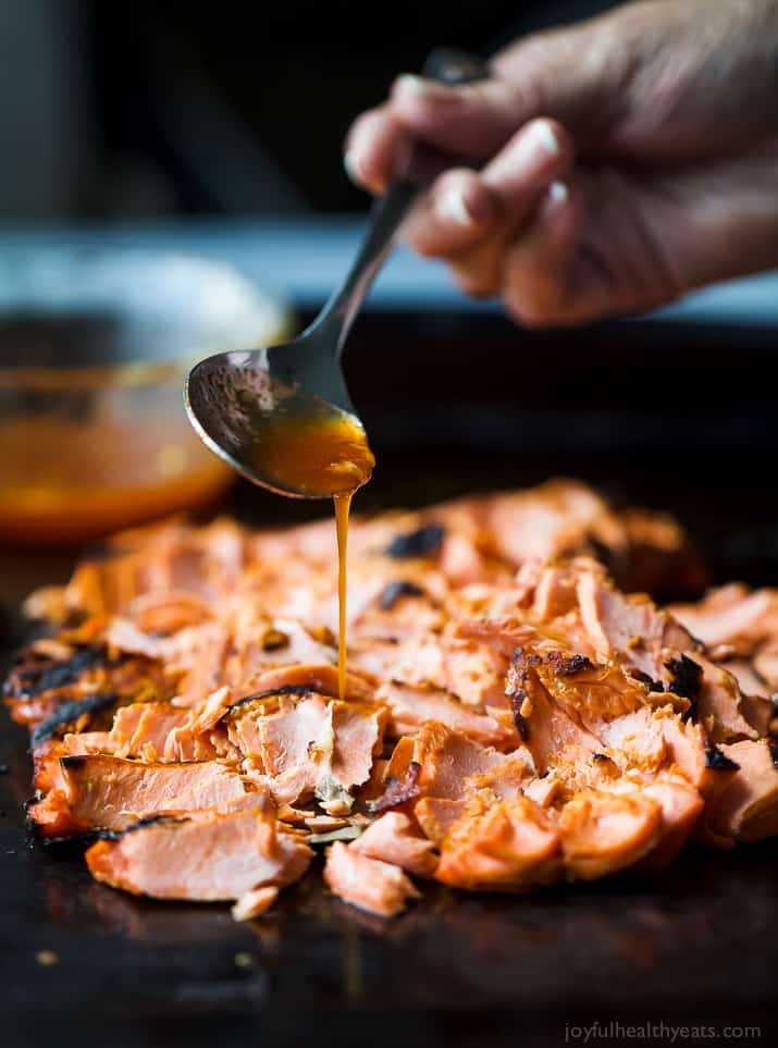 Honey Sriracha sauce being drizzled over Grilled Salmon
