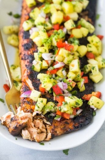 Grabbing a piece of flaky salmon with a fork.