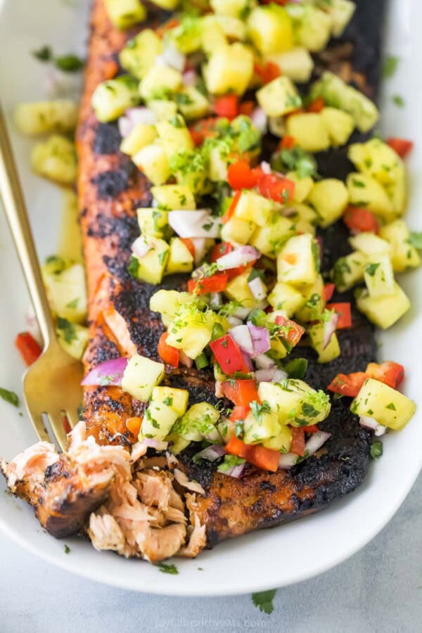 Pick up a piece of flaky salmon with a fork.