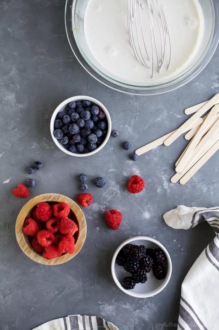 Paleo Berry Coconut Popsicles a sweet refreshing summer treat that's easy to make! These creamy Coconut Popsicles are filled with tart berries and finished with a vanilla bean coconut mixture. They'll be a hit all summer long!