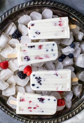 Paleo Berry Coconut Popsicles a sweet refreshing summer treat that's easy to make! These creamy Coconut Popsicles are filled with tart berries and finished with a vanilla bean coconut mixture. They'll be a hit all summer long!