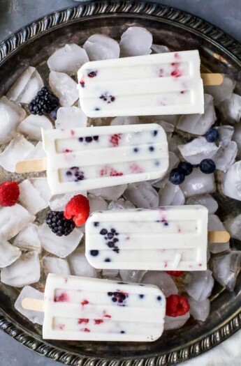 Paleo Berry Coconut Popsicles a sweet refreshing summer treat that's easy to make! These creamy Coconut Popsicles are filled with tart berries and finished with a vanilla bean coconut mixture. They'll be a hit all summer long!