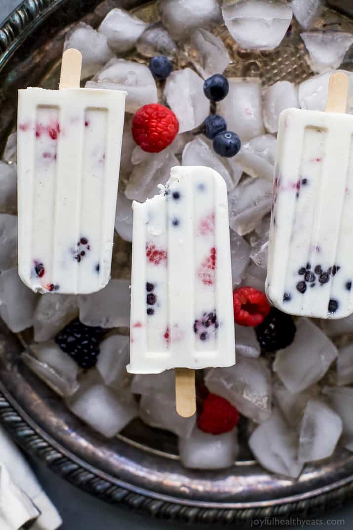 Paleo Berry Coconut Popsicles a sweet refreshing summer treat that's easy to make! These creamy Coconut Popsicles are filled with tart berries and finished with a vanilla bean coconut mixture. They'll be a hit all summer long!