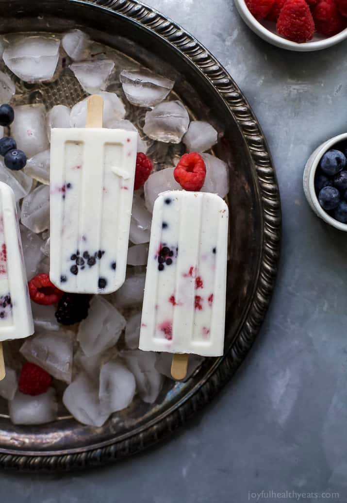 Paleo Berry Coconut Popsicles a sweet refreshing summer treat that's easy to make! These creamy Coconut Popsicles are filled with tart berries and finished with a vanilla bean coconut mixture. They'll be a hit all summer long!