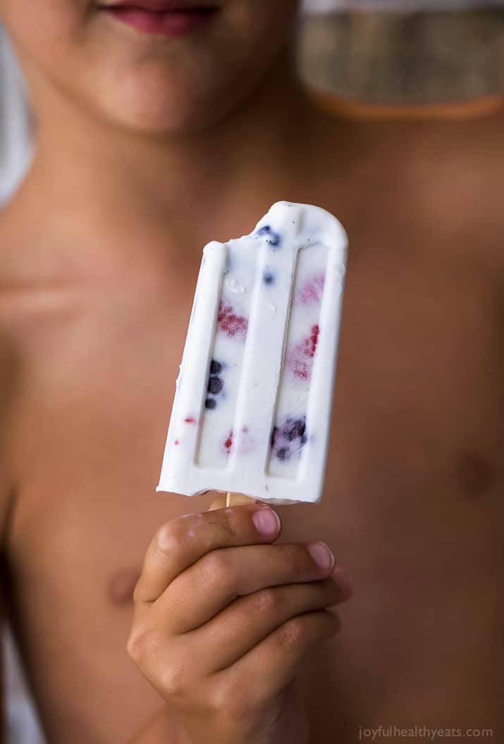 Paleo Berry Coconut Popsicles a sweet refreshing summer treat that's easy to make! These creamy Coconut Popsicles are filled with tart berries and finished with a vanilla bean coconut mixture. They'll be a hit all summer long!