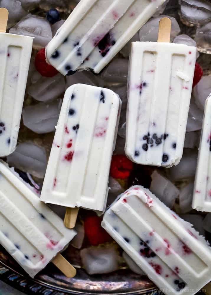 Paleo Berry Coconut Popsicles a sweet refreshing summer treat that's easy to make! These creamy Coconut Popsicles are filled with tart berries and finished with a vanilla bean coconut mixture. They'll be a hit all summer long!