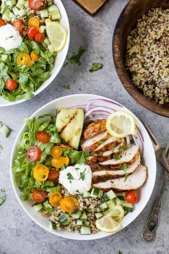 A Middle Eastern quinoa bowl on a granite countertop with two metal forks beside it