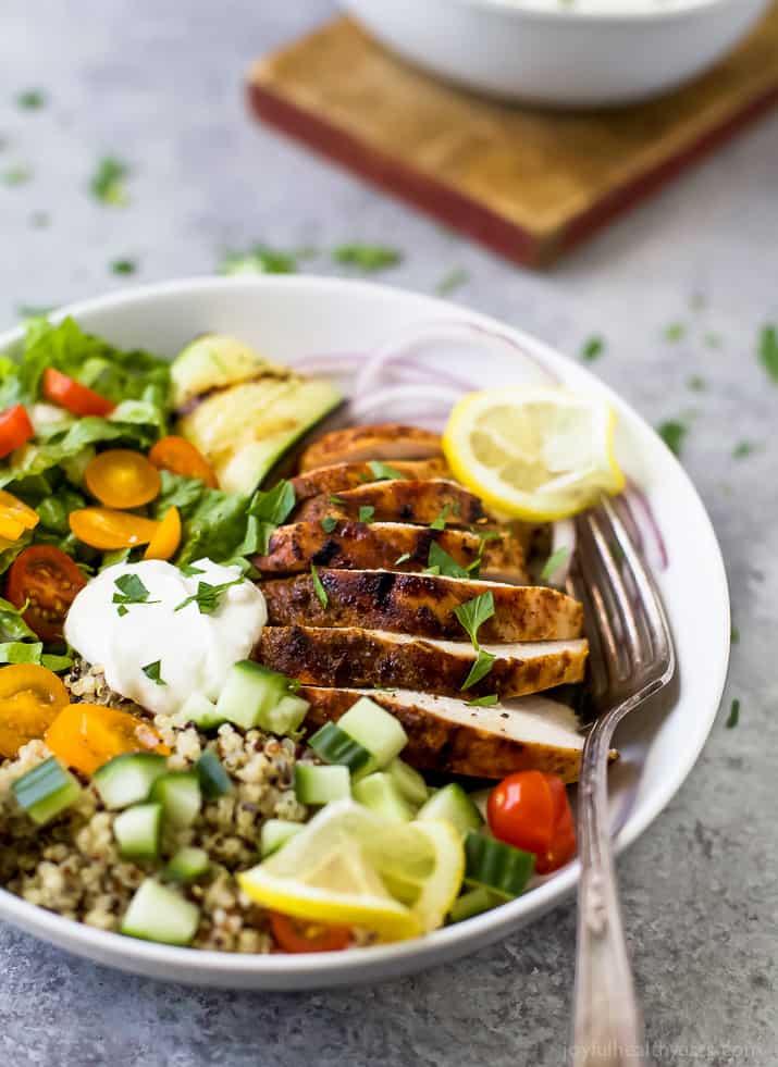 A close-up shot of a chicken quinoa bowl topped with a dollop of homemade yogurt sauce